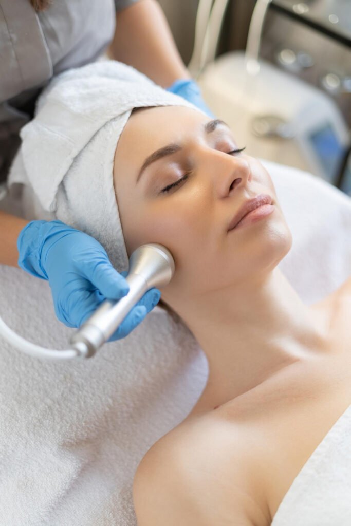 young-woman-lying-cosmetologist-s-table-during-rejuvenation-procedure-cosmetologist-take-care-about-neck-face-skin-youthfull-wellness-hardware-face-cleaning-procedure